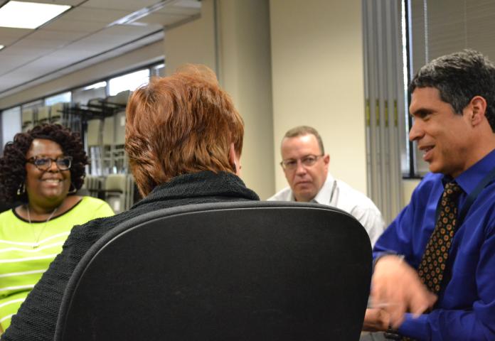 Four employees at a table talking